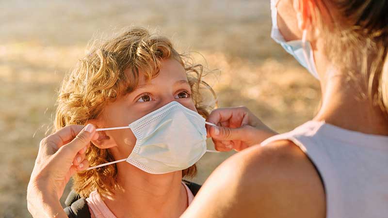 Mãe a colocar máscara no filho